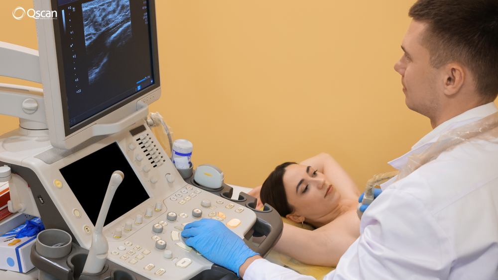 Patient lying down during a breast ultrasound, with a sonographer using the ultrasound probe beside the scanning machine at South East Radiology.