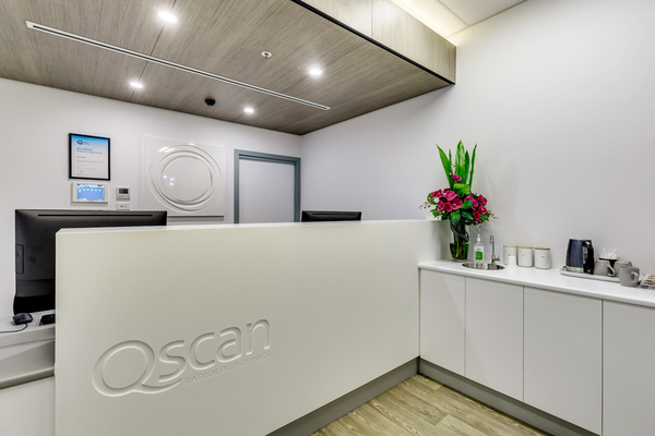Reception area at the Qscan Hobart clinic, featuring the Qscan Radiology Clinics logo and a comfortable waiting space.