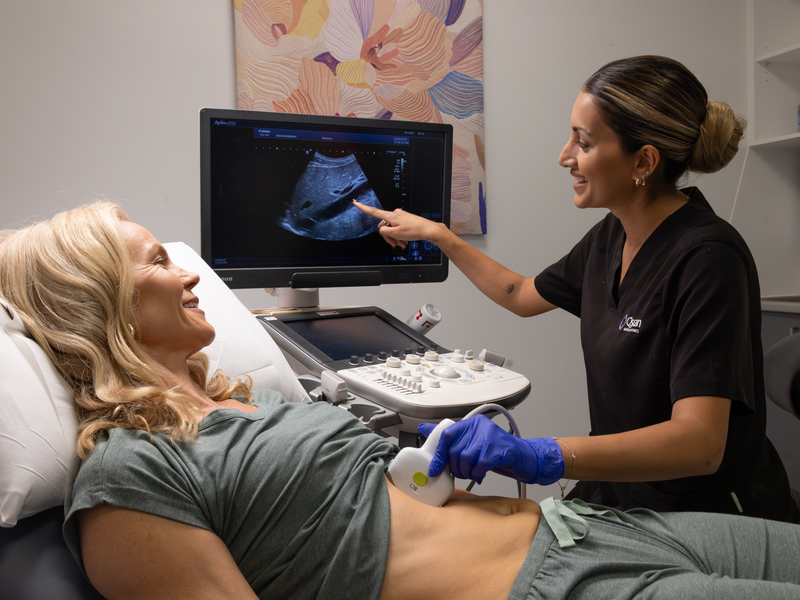 Qscan sonographer performing an abdominal ultrasound scan with a smiling female patient at Qscan Windsor clinic