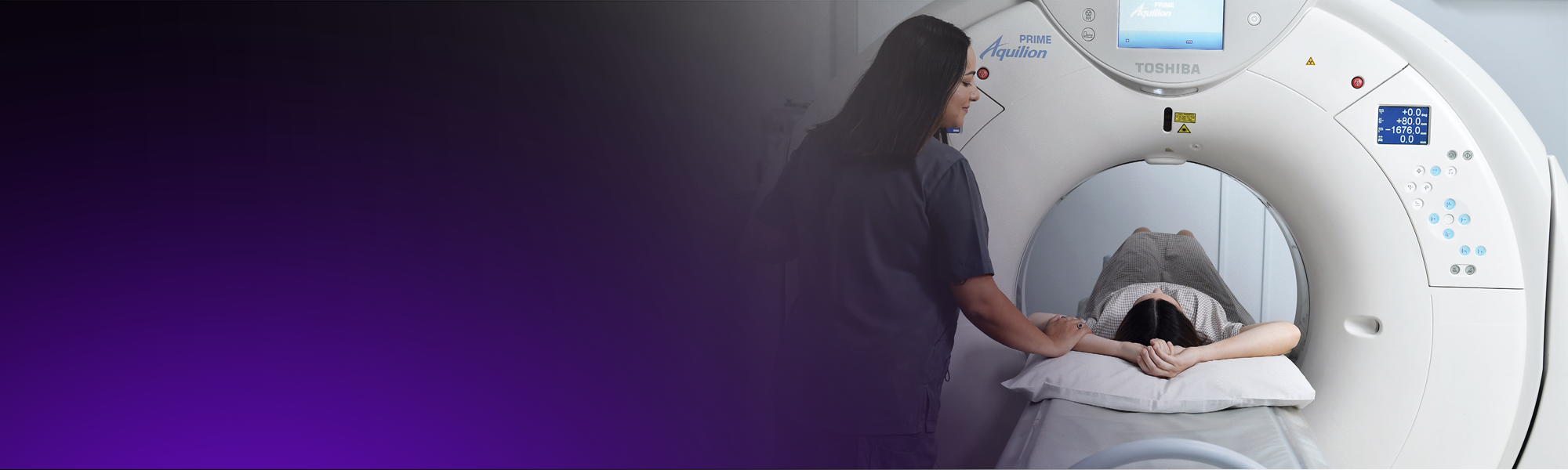 A female radiographer positions a patient for a CT scan