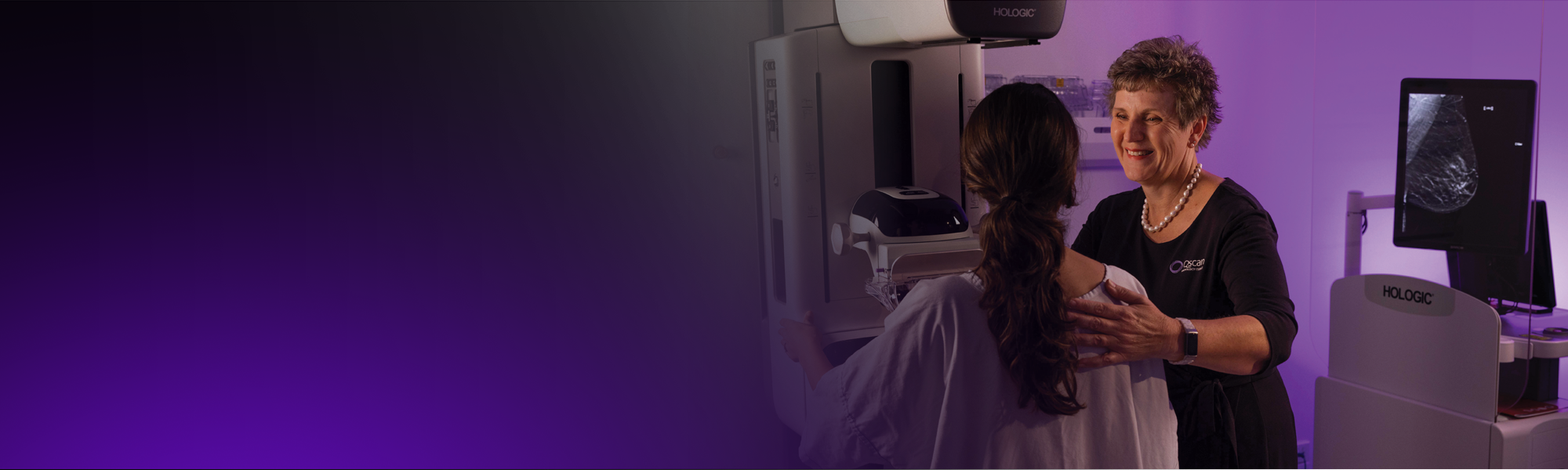 A radiographer positions a mammography patient for a scan.
