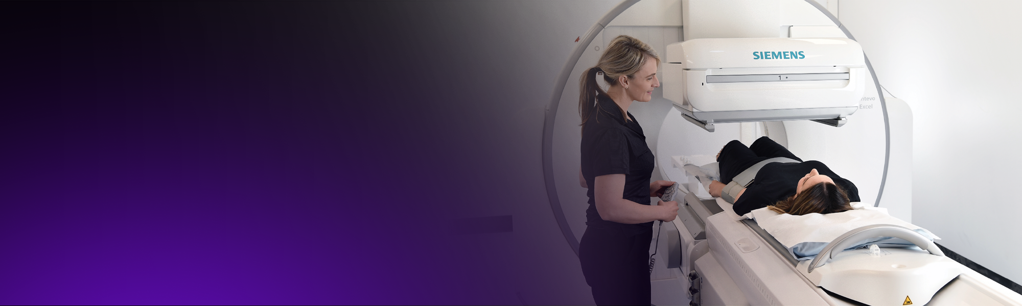 A nuclear medicine technologist positions a patient for a nuclear medicine scan.