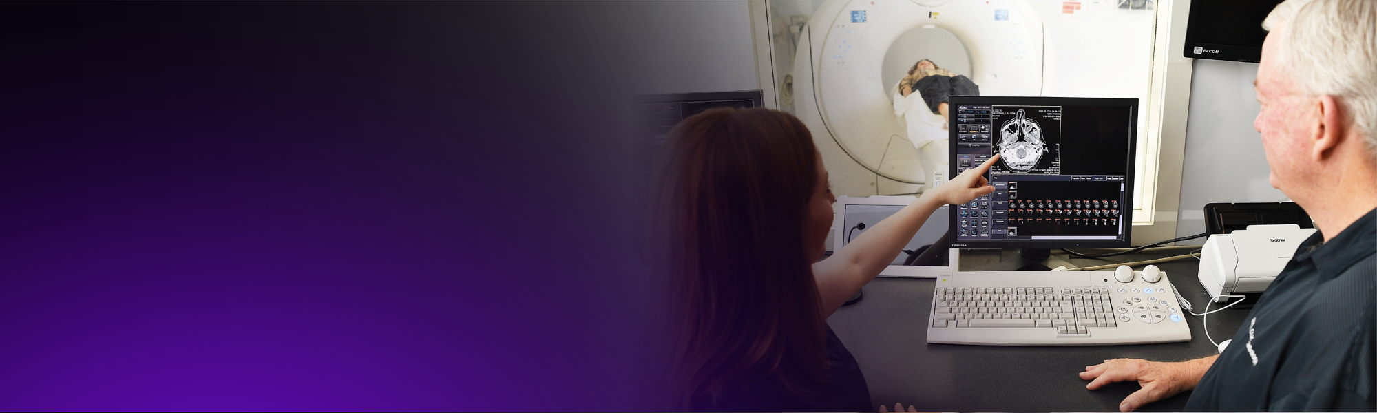 A female and male radiographer run a CT scan for a patient